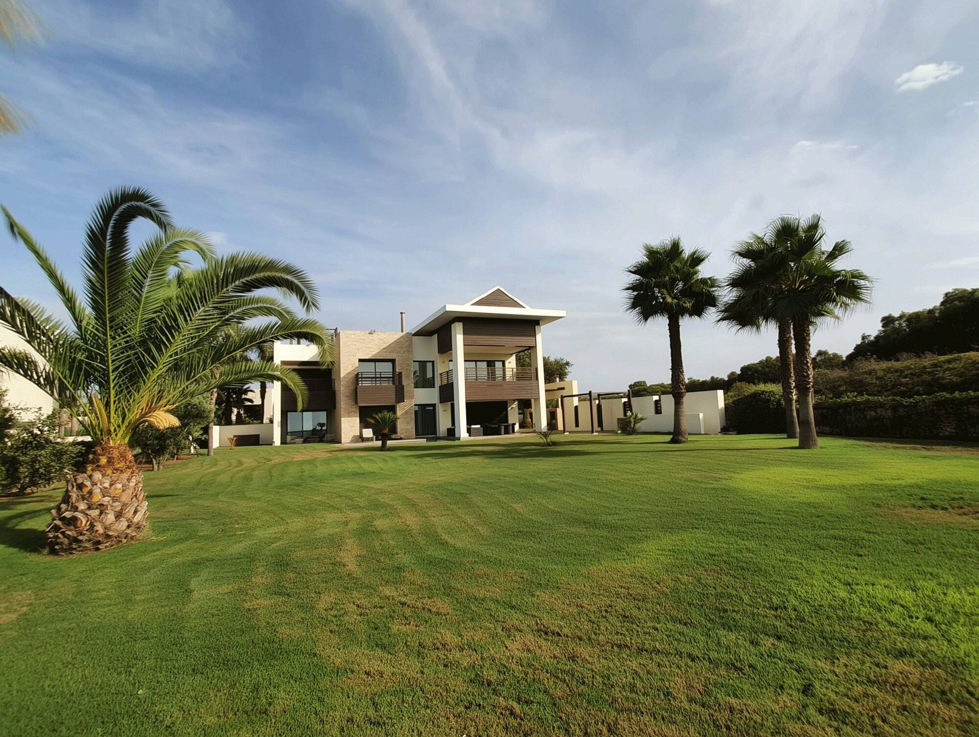 Luxury villa accommodation at the American Golf Academy’s Junior Golf Academy, with palm trees, manicured lawns, and a clear blue sky — perfect for golf retreats and student housing.